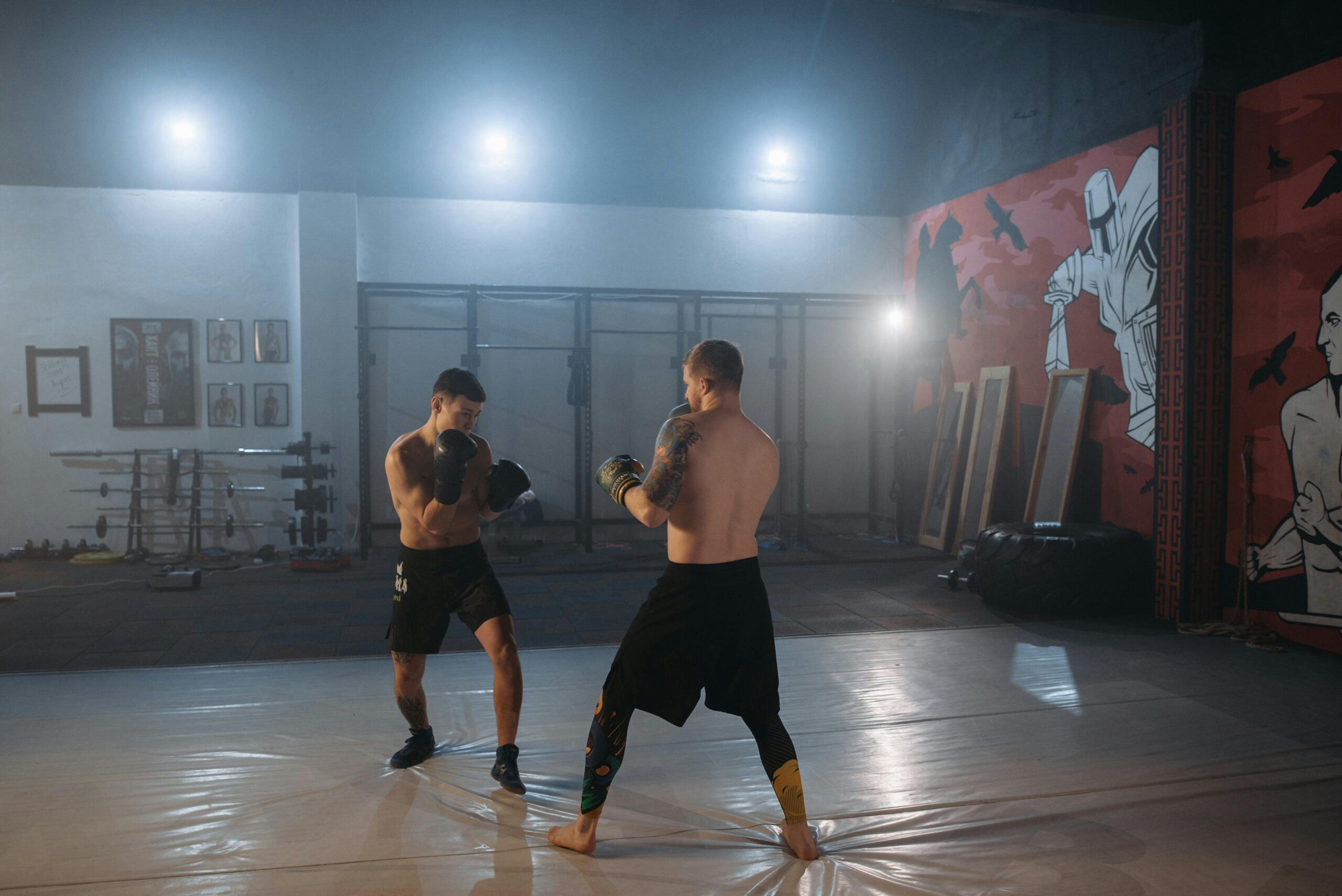 Two boxers practicing techniques in a modern gym setting.